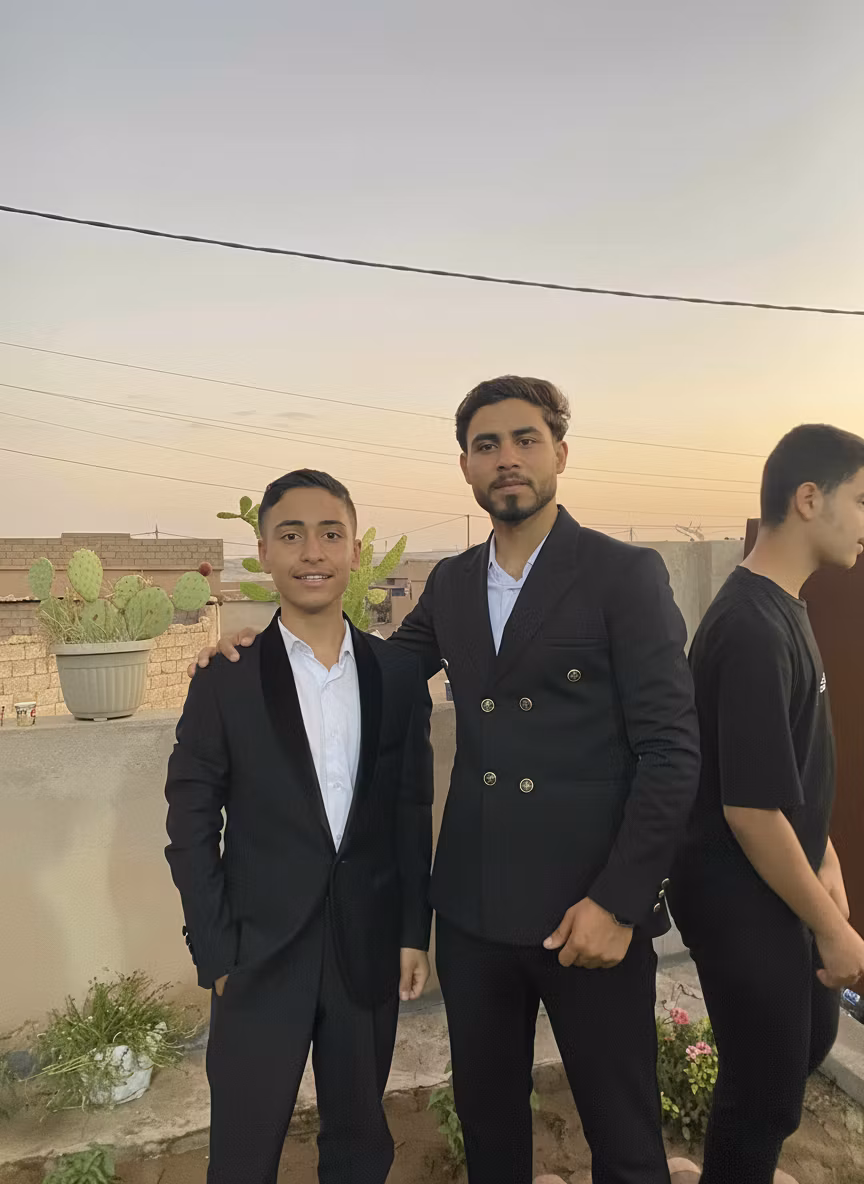 Mhde Mhde – Using the provided image of three young men standing outdoors, modify only the person on the far right who is current…