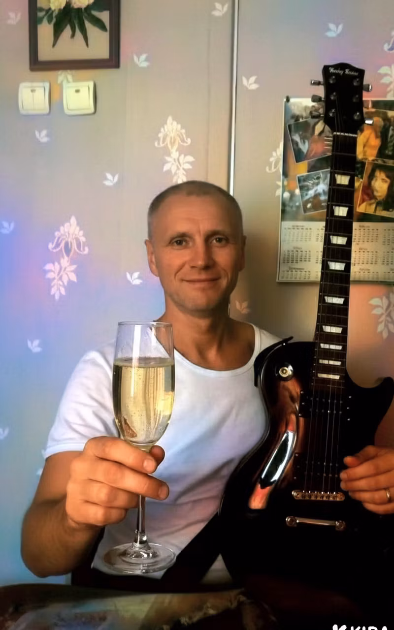 Wowa – Edit the scene so that the man holding the black electric guitar picks up a elegant champagne flute filled with spark…